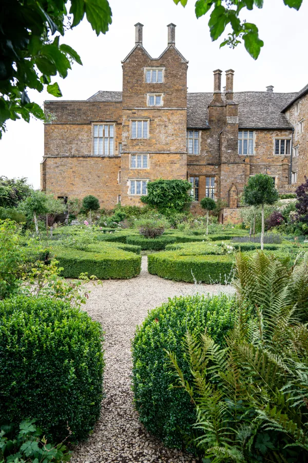 Broughton Castle: the honey-stone façade and walled gardens in summer