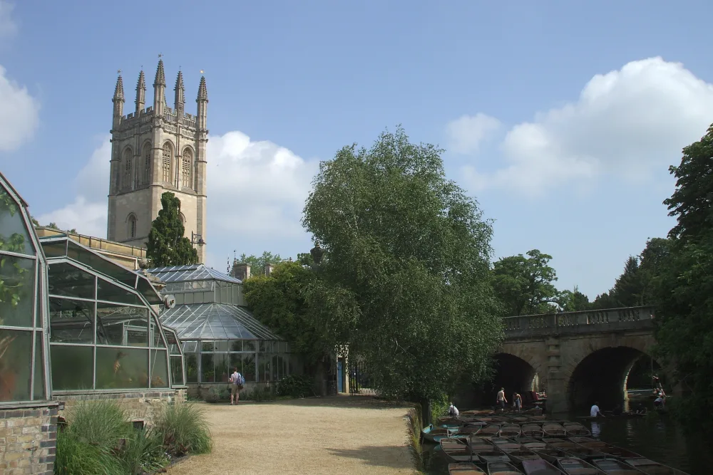 The Victorian glasshouses of Oxford Botanic Garden with Magdalen tower and the River Cherwell behind