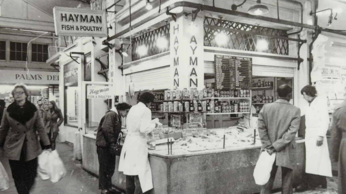 Hayman fish and poultry counter in Oxford Covered Market, beside Palm's Deli, with shoppers in winter coats