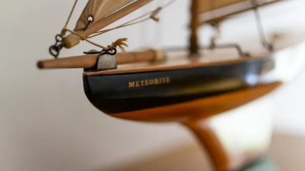 A model sailing yacht named Meteorite on the bedroom dresser