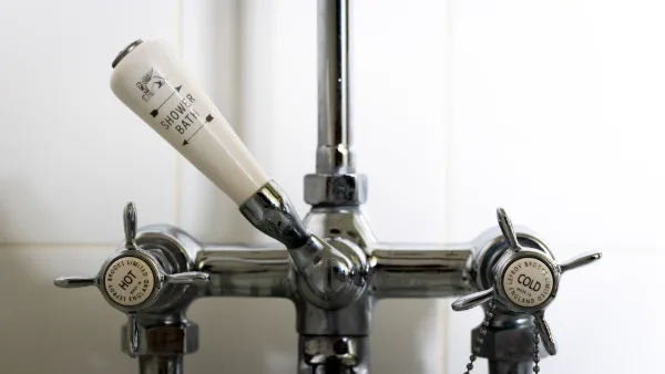 Victorian-style bath taps with porcelain hot and cold handles and a shower diverter
