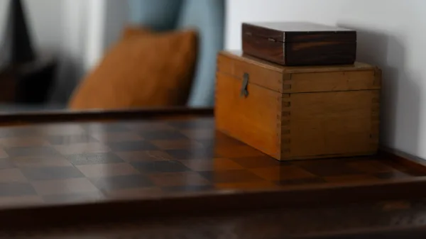 An inlaid chess table with vintage wooden boxes in the sitting room