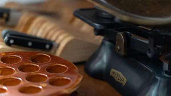 Vintage kitchen scales, a terracotta egg rack and knives on the oak worktop
