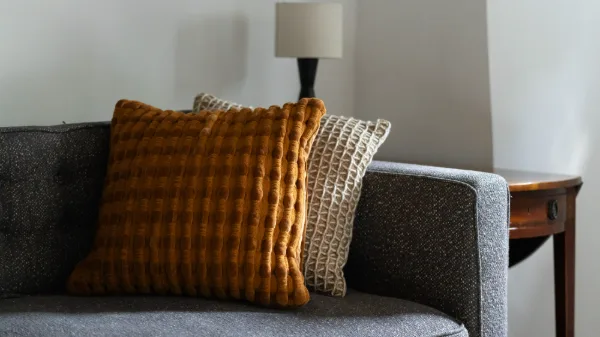 Textured amber and cream cushions on the grey tweed sofa in the sitting room
