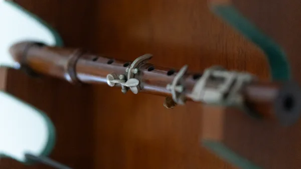 A vintage wooden clarinet resting in a display stand in the library
