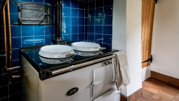 The cream Aga with chrome lids closed in its blue-tiled alcove