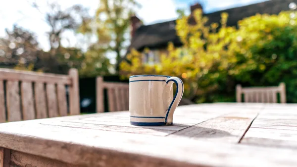 Morning coffee on the garden terrace at Well Cottage, with the walled garden and stone walls in soft early light