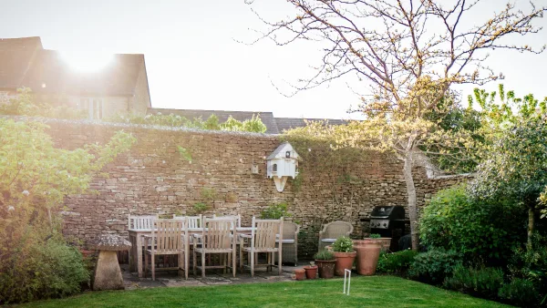 The dry-stone garden wall at Well Cottage lit in warm sunset gold, the sky behind fading to amber