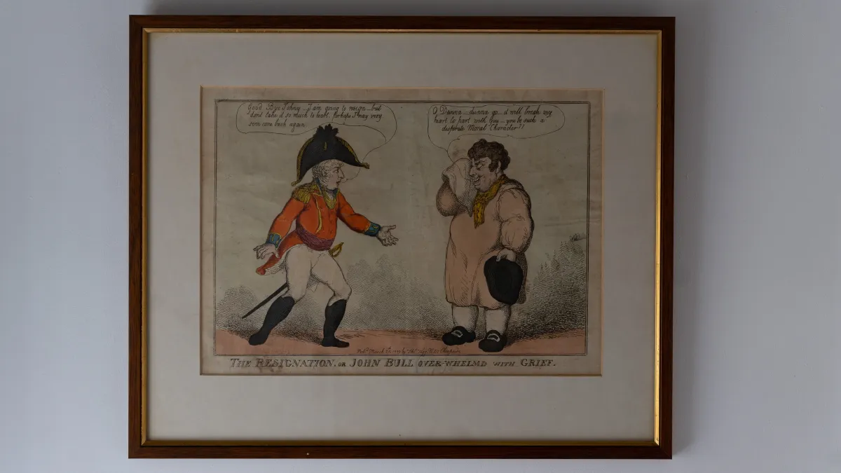 A framed, hand-coloured Rowlandson cartoon — "The Resignation, or John Bull Over-Whelm'd With Grief" — hanging on the wall of the downstairs bathroom