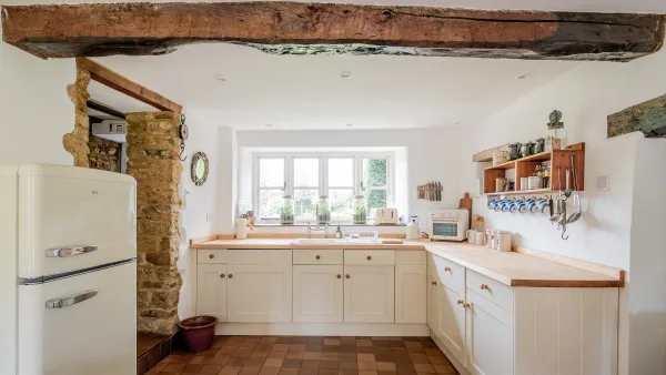 The Aga kitchen at Well Cottage with butler cabinetry and a quarry-tiled floor