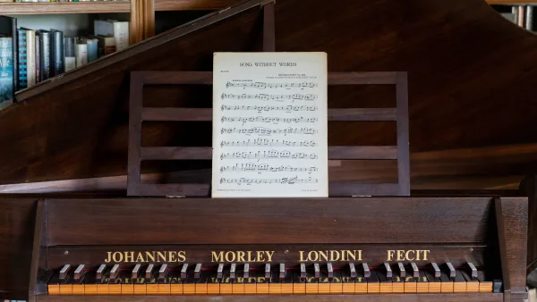 A small chamber organ and vintage harpsichord in the library at Well Cottage, music sheets on the stand