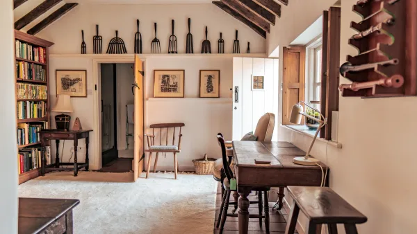 The library at Well Cottage with bookshelves and a garden-view writing desk