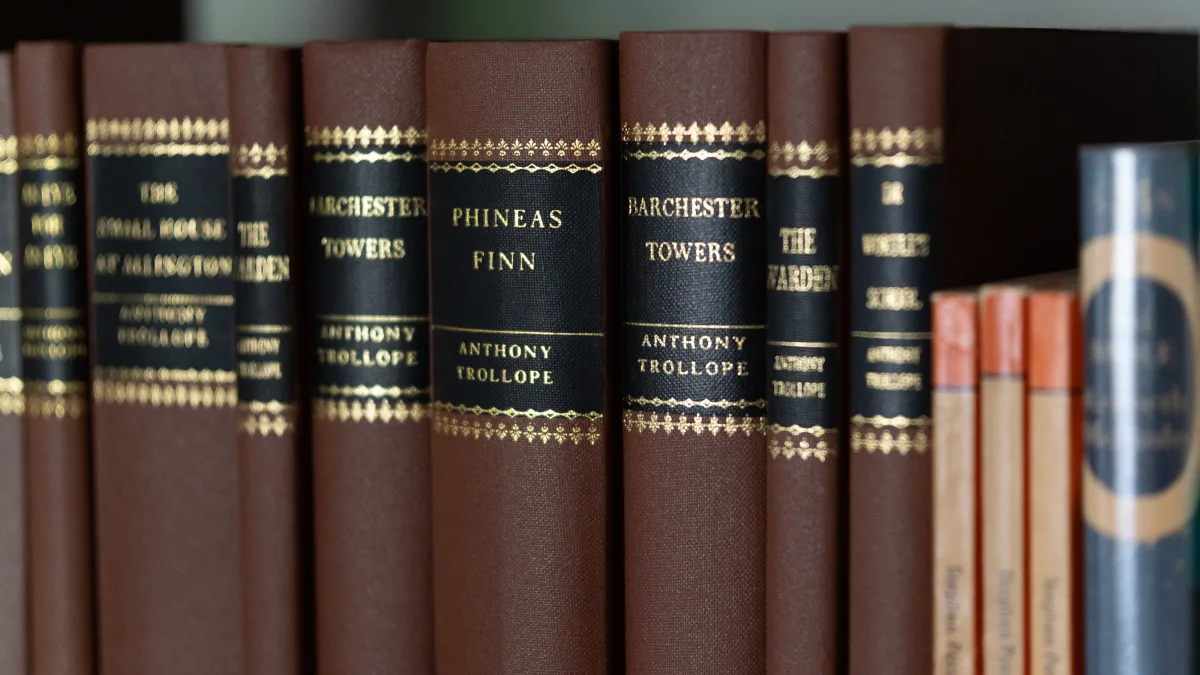 Gilt-spined hardback volumes of Anthony Trollope novels — Barchester Towers, Phineas Finn, The Warden — on the library shelves