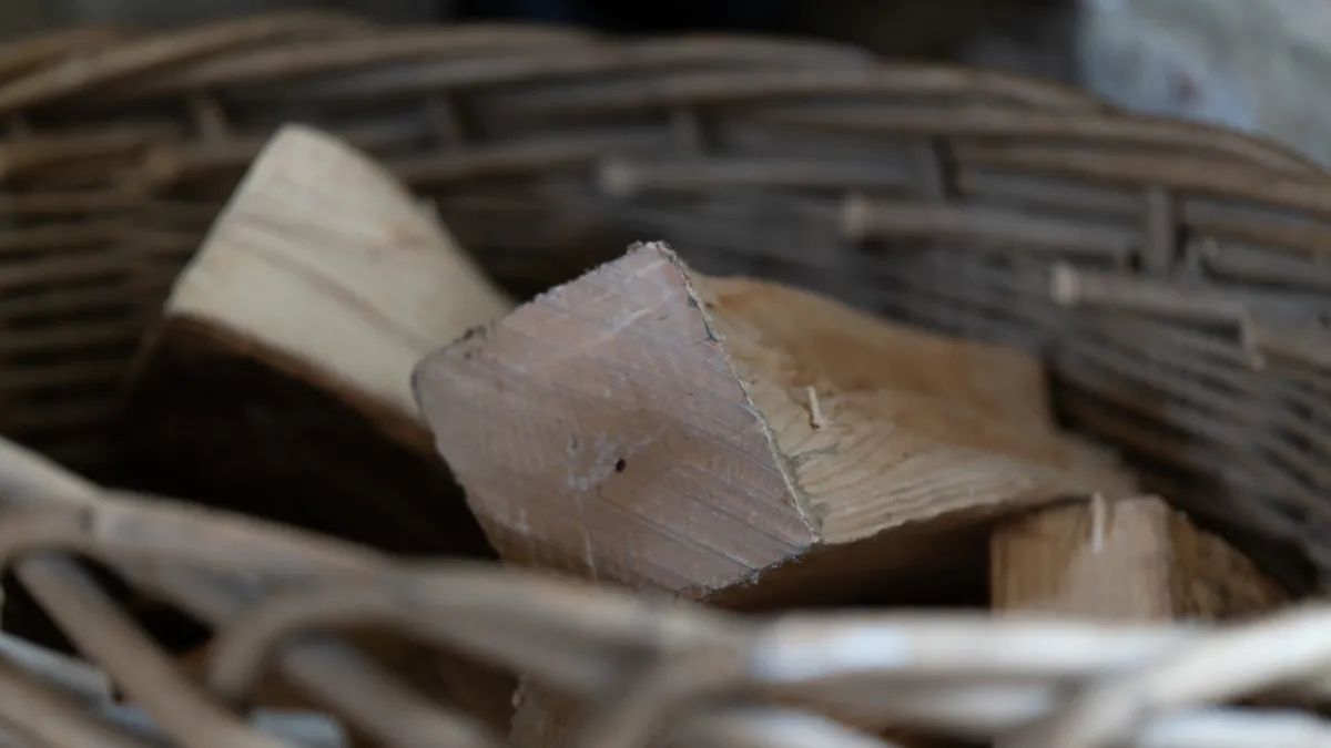 A close-up of split logs piled in a woven willow basket by the hearth