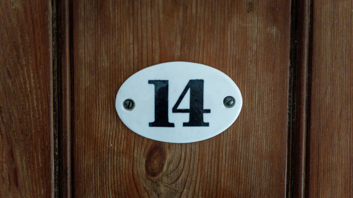 The enamel number fourteen plate fixed to the room's panelled wooden door